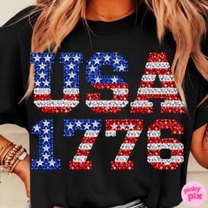 K&ouml;nnte beinhalten: Schwarzes T-Shirt mit dem Text "USA 1776". Die Buchstaben und Zahlen sind mit rot, wei&szlig; und blau glitzernden Sternen und Streifen verziert, die die amerikanische Flagge darstellen.