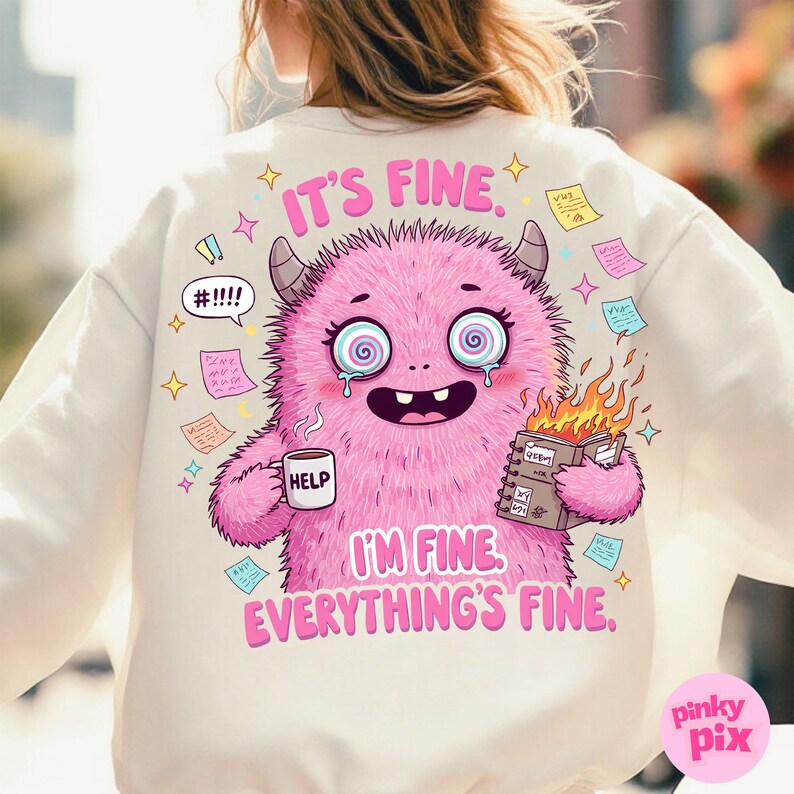 May include: A white sweatshirt with a pink monster graphic and the text "It's fine. I'm fine. Everything's fine." The monster has a distressed look with spiral eyes and is holding a cup that says "Help" and a notebook with flames coming out of it.