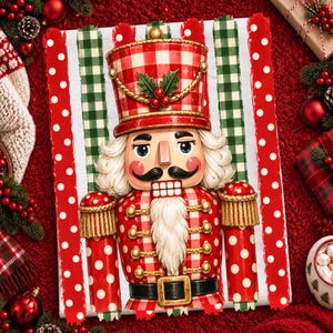 May include: A rectangular decorative sign featuring a central nutcracker illustration with a red and white buffalo check pattern, a black belt, gold accents, and a white beard, set against a background of vertical red, white, and green stripes.