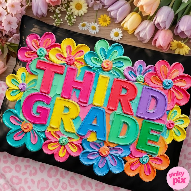May include: A black pillow decorated with colorful, dimensional flowers and the words "THIRD GRADE" in bright, bold letters. The flowers are in shades of pink, yellow, blue, and orange.