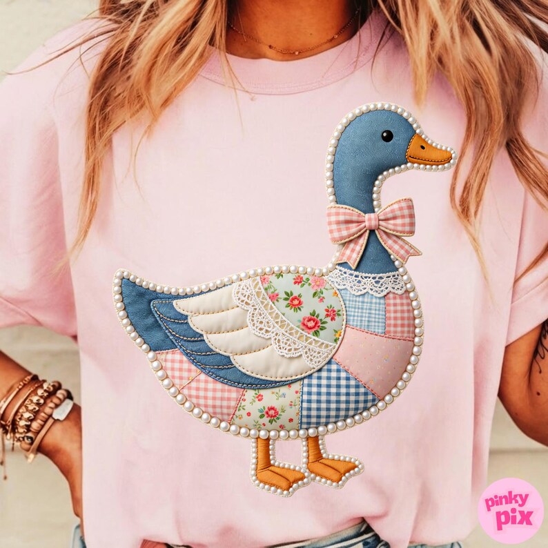 K&ouml;nnte beinhalten: Rosa T-Shirt mit einem G&auml;nsemotiv im Patchwork-Stil. Die Gans hat einen blauen Kopf, einen orangefarbenen Schnabel und eine rosa Schleife. Der K&ouml;rper besteht aus verschiedenen gemusterten Stoffen, darunter Blumen und Vichy, und ist mit Perlen umrandet.
