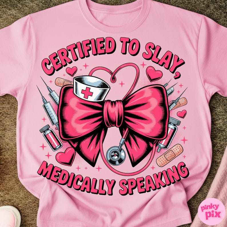 May include: Pink t-shirt with the text "CERTIFIED TO SLAY, MEDICALLY SPEAKING" in a stylized font. The graphic features a large pink bow, a nurse's hat, a stethoscope, syringes, and hearts.