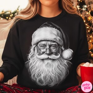 May include: Black sweatshirt featuring a detailed black and white illustration of Santa Claus. The image shows Santa with a long white beard, glasses, and a traditional hat. A festive holiday design.