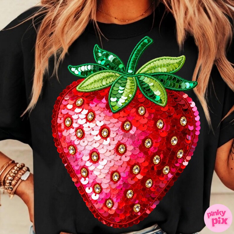 K&ouml;nnte beinhalten: Schwarzes T-Shirt mit einem gro&szlig;en, paillettenbesetzten Erdbeer-Design. Die Erdbeere ist rot und rosa mit gr&uuml;nen Bl&auml;ttern und Stiel und mit klaren Strasssteinen verziert. Das Design ist auf dem T-Shirt zentriert.