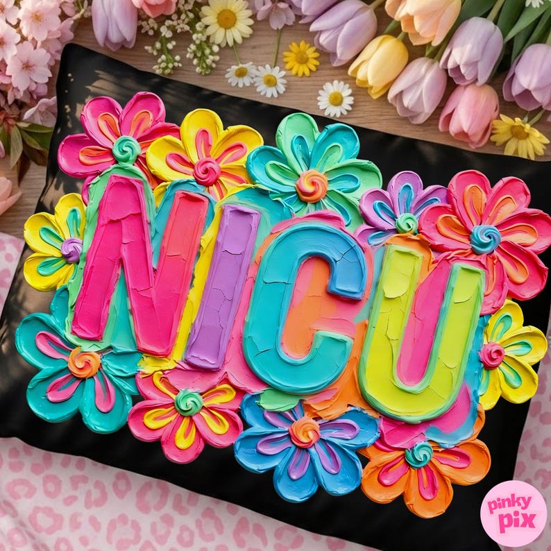 Op de afbeelding: Zwart kussen met het woord "NICU" in heldere, getextureerde letters, omringd door kleurrijke, gebeeldhouwde bloemen in roze, geel, blauw en oranje. Het kussen heeft een getextureerde, geschilderde uitstraling.