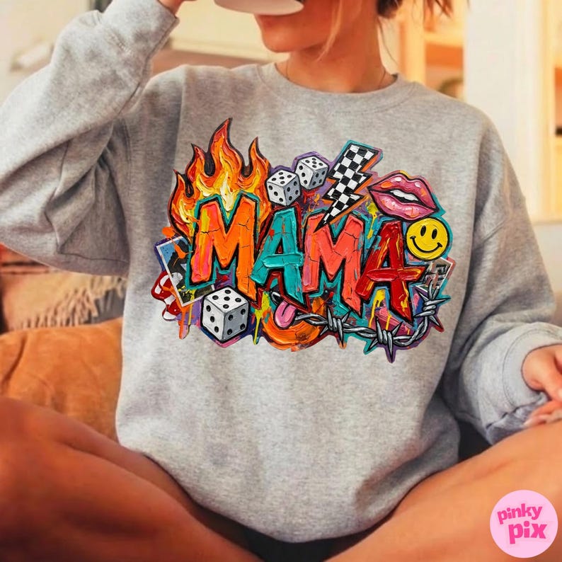 May include: A gray sweatshirt with a colorful graphic that says "MAMA" in graffiti style. The design includes flames, dice, a lightning bolt, lips, a smiley face, and barbed wire.