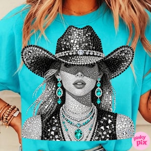 May include: A turquoise t-shirt featuring a mosaic-style illustration of a woman wearing a black cowboy hat and jewelry. The hat and jewelry are embellished with sparkling crystals. The woman's earrings and necklace feature turquoise gemstones.
