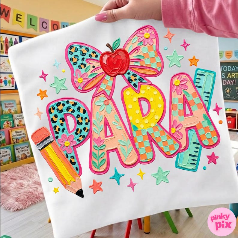 May include: White fabric with the word "PARA" in colorful, textured letters. A large bow with an apple, pencil, and ruler are also featured. The design includes stars and floral accents, perfect for a teacher or classroom.