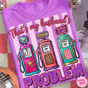 May include: A purple t-shirt with a graphic of three vintage gas pumps in pink, orange, and teal. The text "That's my husband's PROBLEM" is in pink and purple. The gas pumps have star and leopard print details.