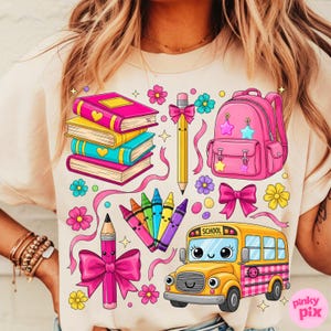 Pu&ograve; includere: T-shirt beige chiaro con una grafica colorata a tema scolastico. Il design include libri, uno zaino, matite, pastelli, fiori, nastri e un autobus scolastico. Il design utilizza colori rosa acceso, giallo, blu e verde.
