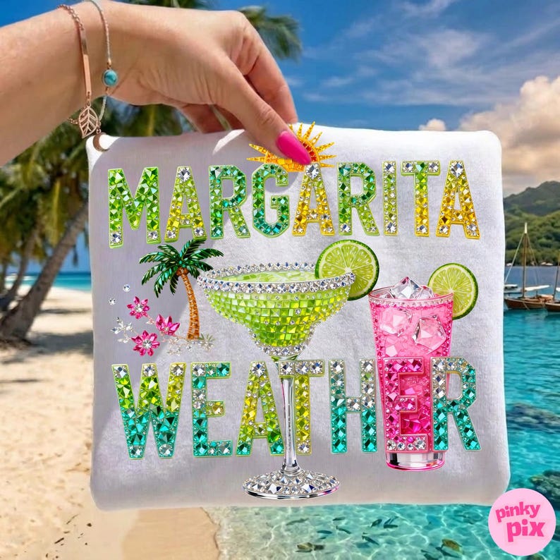 Peut inclure: Serviette de plage blanche avec l'inscription "MARGARITA WEATHER" en lettres vertes et dor&eacute;es scintillantes. La serviette pr&eacute;sente un verre &agrave; margarita, un cocktail rose, un palmier et des tranches de citron vert, le tout orn&eacute; de strass. Une journ&eacute;e ensoleill&eacute;e &agrave; la plage.