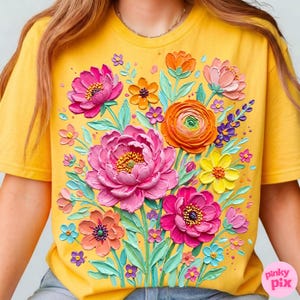 May include: Yellow t-shirt featuring a vibrant floral design. The graphic includes large pink peonies, orange ranunculus, and various other colorful flowers with green leaves. The design has a textured, painted appearance.