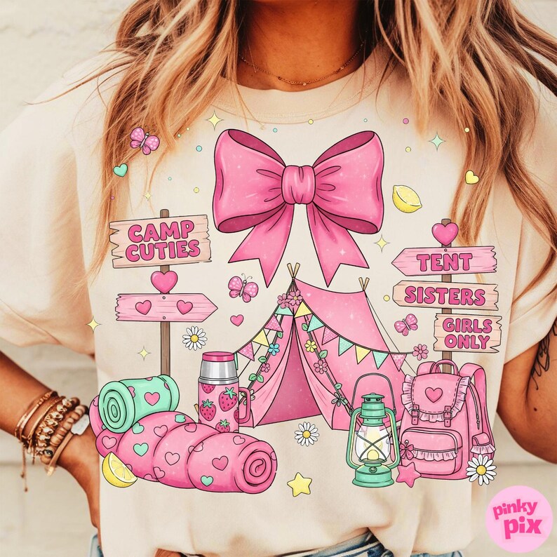 May include: A light beige t-shirt with a pink camping scene. The design includes a large bow, tent, and the words "Camp Cuties", "Tent Sisters", and "Girls Only". Butterflies, hearts, and a backpack are also featured.