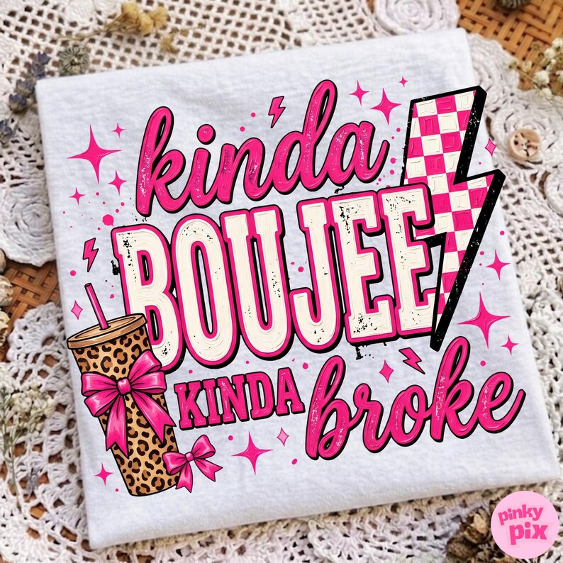 May include: A white t-shirt featuring a graphic design with the text "kinda BOUJEE kinda broke" in pink and white. The design includes a leopard print tumbler with a pink bow, a pink and white checkered lightning bolt, and pink star accents.