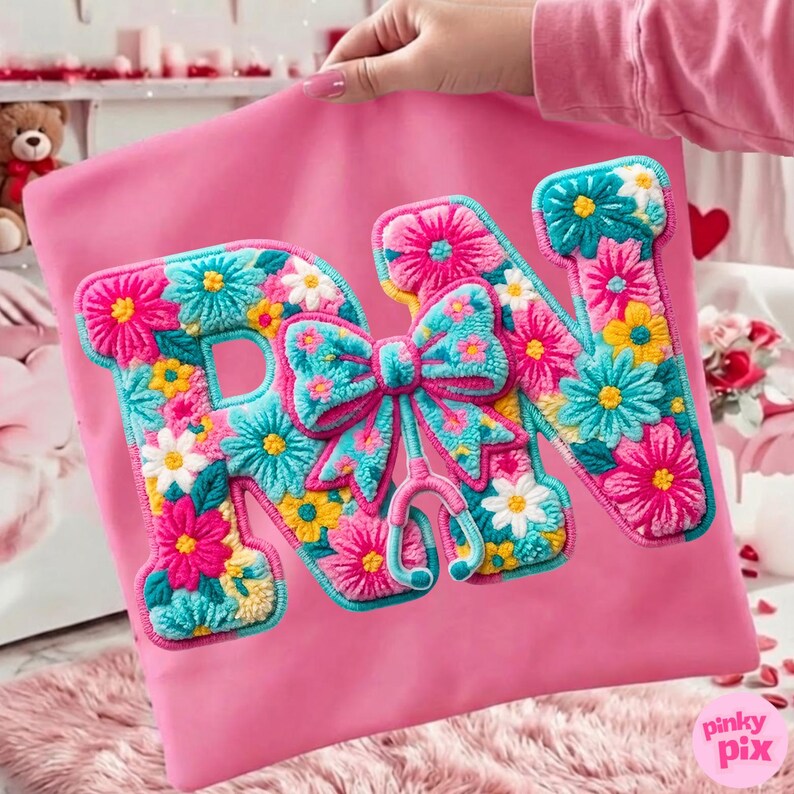 May include: A pink pillowcase with the embroidered letters "RN" in a floral design. The letters are outlined in turquoise and filled with pink, yellow, and white flowers. A turquoise bow and stethoscope are in the center.