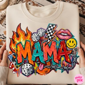 May include: Cream-colored sweatshirt with a vibrant graffiti-style design. The word "MAMA" is prominently displayed in bold, colorful letters, surrounded by flames, dice, a lightning bolt, lips, a smiley face, and barbed wire.
