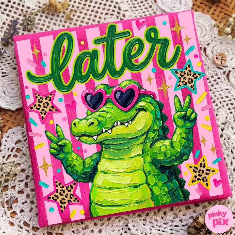 May include: A square canvas art piece with a pink striped background and the word "later" in green script. A green alligator wearing heart-shaped sunglasses gives a peace sign. Leopard print stars and gold starbursts decorate the canvas.
