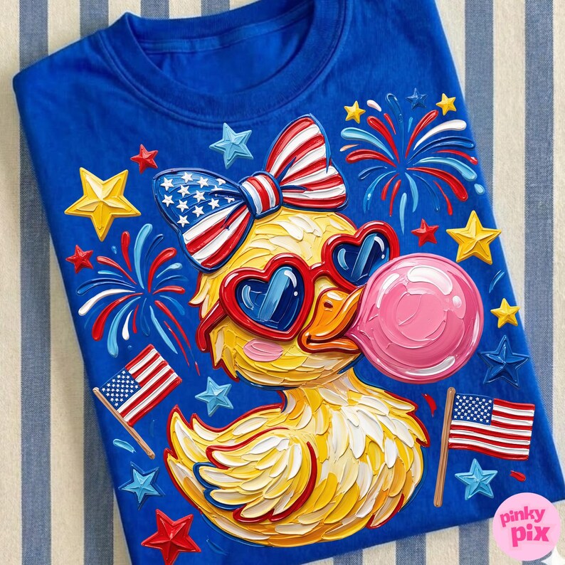May include: Blue t-shirt featuring a yellow duck wearing heart-shaped sunglasses and a bow, both in red, white, and blue. The duck is blowing a pink bubble and surrounded by fireworks, stars, and American flags.