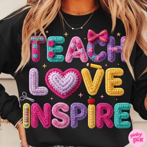 Pu&ograve; includere: Felpa nera con le parole "TEACH LOVE INSPIRE" in lettere colorate e strutturate, in stile uncinetto. Il design include un cuore, un fiocco, una matita, delle forbici e una mela. Tema insegnante.