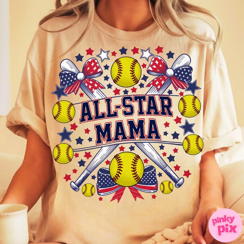 May include: Beige t-shirt with a softball-themed design. The design includes yellow softballs, baseball bats, red and blue bows, and stars. The text "ALL-STAR MAMA" is prominently displayed in navy blue and white.