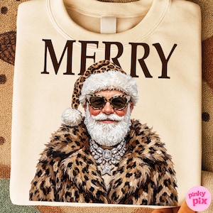 以下が含まれることがあります： クリーム色のスウェットシャツ。茶色の文字で「MERRY」と書かれ、その下に白い髭を生やし、ヒョウ柄のサンタ帽、ヒョウ柄のサングラス、ヒョウ柄のコート、大きなクリスタルのネックレスを身につけた人物のグラフィックがプリントされています。
