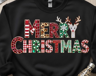 Może przedstawiać: Czarna bluza z okrągłym dekoltem z napisem "MERRY CHRISTMAS" w świątecznym, kolorowym wzorze. Litery zdobione są różnymi wzorami, w tym paskami, panterką i kratą. Nad słowem "MAS" znajdują się dwa renifery.