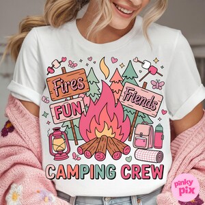 May include: White t-shirt with a colorful camping graphic. The design includes a campfire, signs that read "Fires, Fun, Friends", and camping gear. The words "Camping Crew" are printed at the bottom.