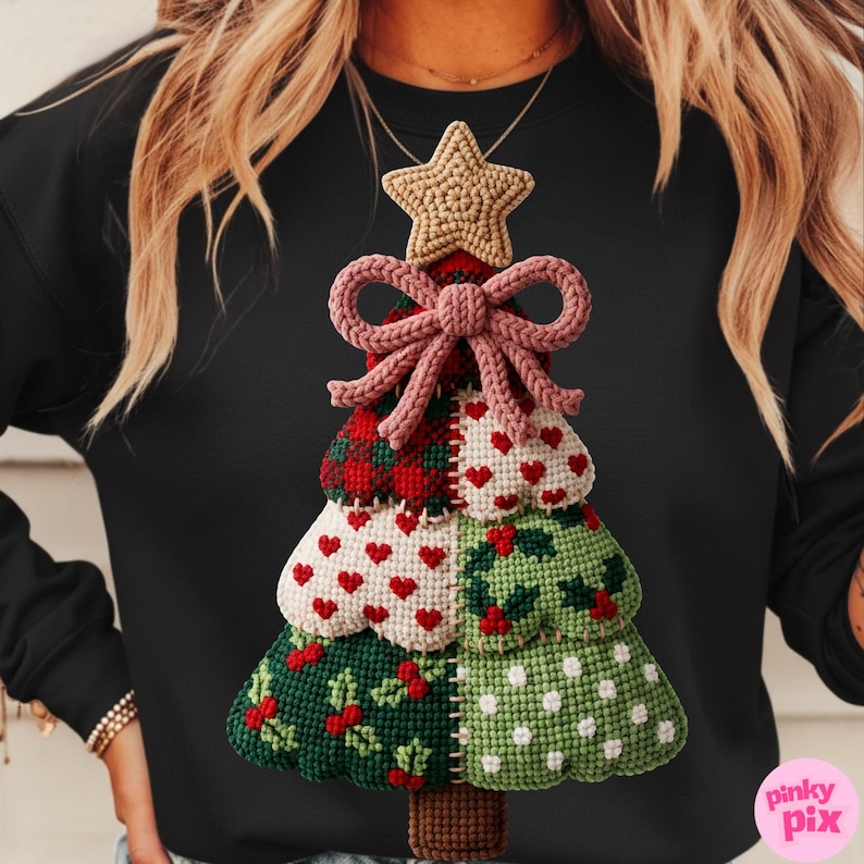 May include: Black sweatshirt featuring a detailed, handmade Christmas tree design. The tree is composed of various textured sections, including red hearts, green holly, and white polka dots, topped with a star and a pink bow.