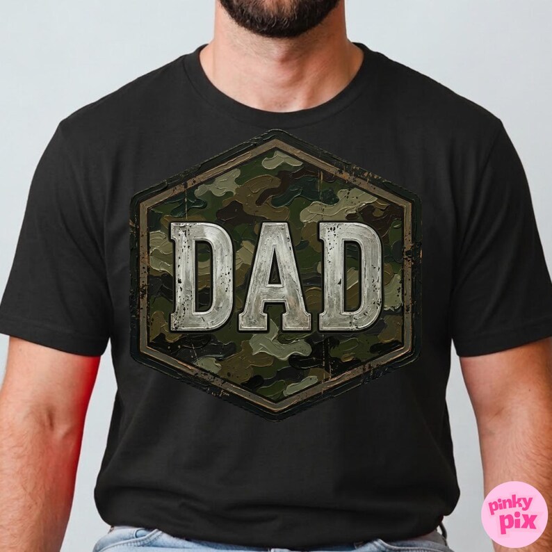 Pode incluir: Camiseta preta com um design hexagonal de camuflagem. A palavra "DAD" &eacute; exibida em letras prateadas desgastadas. O design tem uma est&eacute;tica robusta de inspira&ccedil;&atilde;o militar. A camiseta &eacute; um estilo de gola redonda cl&aacute;ssico.