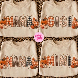May include: Four beige crewneck sweatshirts featuring autumn-themed graphics. Each shirt displays a different name: MAMA, GIGI, NANA, or MIMI. The letters are filled with orange gingham, floral, and black plaid patterns, surrounded by pumpkins and stars.