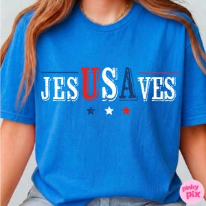 May include: A blue t-shirt with the text "JES US SAVES" in white, red, and blue. The design includes three stars in blue, white, and red. The shirt is a short-sleeved crew neck.
