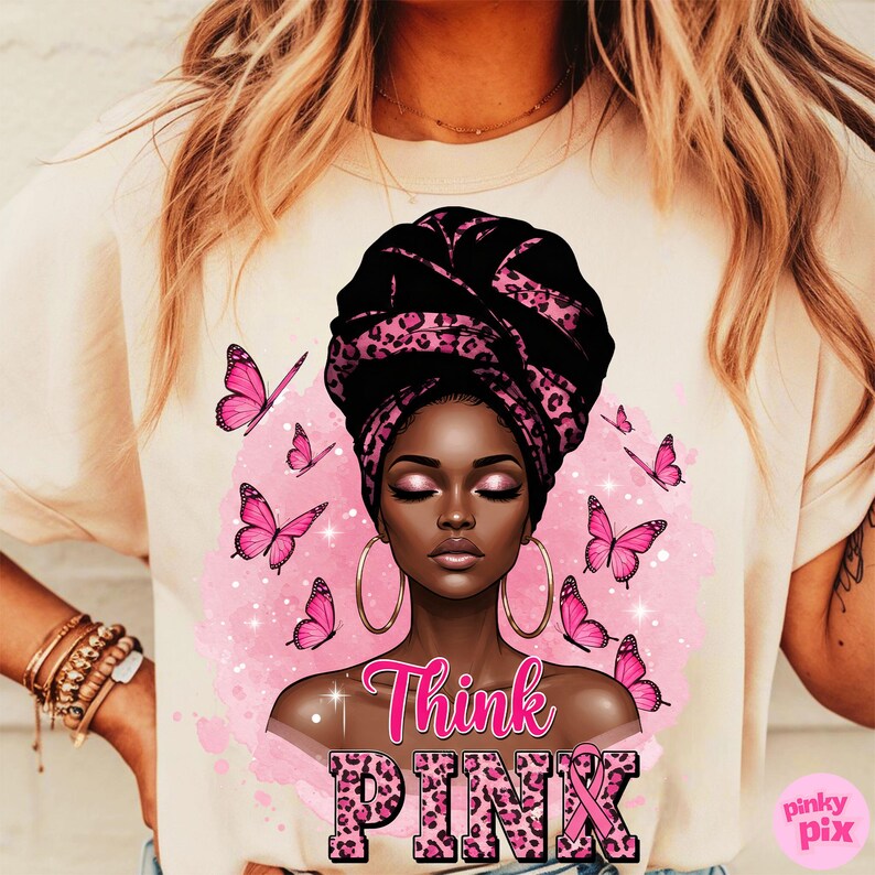 K&ouml;nnte beinhalten: Cremefarbenes T-Shirt mit einer Grafik einer schwarzen Frau mit einem schwarz-rosa Leoparden-Kopftuch und goldenen Creolen. Rosa Schmetterlinge und die Worte "Think PINK" sind ebenfalls abgebildet.