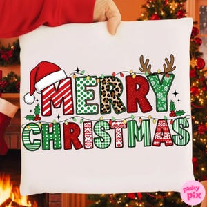 Könnte beinhalten: Weißes Kissen mit dem Schriftzug "MERRY CHRISTMAS" in einem festlichen Design. Die Buchstaben sind mit Mustern wie Streifen, Punkten und Animal-Print verziert, sowie mit einem Weihnachtsmannhut und Rentiergeweih.
