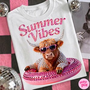 May include: White t-shirt with the text "Summer Vibes" in pink rhinestones. The shirt features a brown Highland cow wearing sunglasses and a bejeweled floatie. The cow is also wearing a bejeweled jacket. The image has a pink and black checkered background.