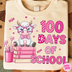 Pu&ograve; includere: Felpa color crema con una grafica che celebra i 100 giorni di scuola. Il design presenta una mucca dei cartoni animati con occhiali a forma di stella e un papillon, seduta su libri rosa. Il testo rosa recita "100 giorni di scuola."