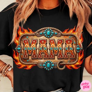 May include: Black t-shirt featuring a decorative design with the word "MAMA" in a western-style font. The design includes a wooden-look frame, turquoise accents, and a flame-like border. The shirt is a casual wear item.