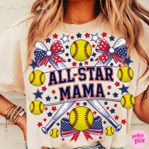 May include: Cream-colored t-shirt with a softball-themed design. The design includes yellow softballs, crossed baseball bats, and the text "ALL-STAR MAMA" in red and blue. Patriotic stars and bows complete the design.