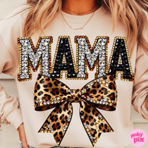 May include: A beige sweatshirt with the word "MAMA" in jeweled letters. The "M" and "A" are outlined in gold and filled with clear rhinestones, while the center "A" is black. A leopard print bow with rhinestone accents is below the text.
