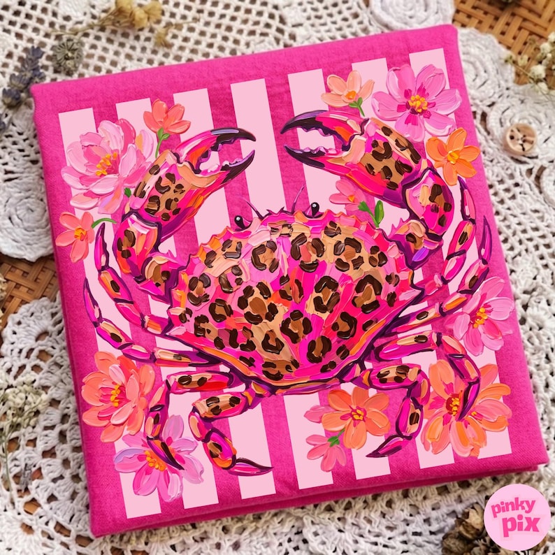 May include: A pink square canvas featuring a crab with a leopard print pattern on its shell and claws. The crab is surrounded by pink and orange flowers. The background has vertical white stripes.