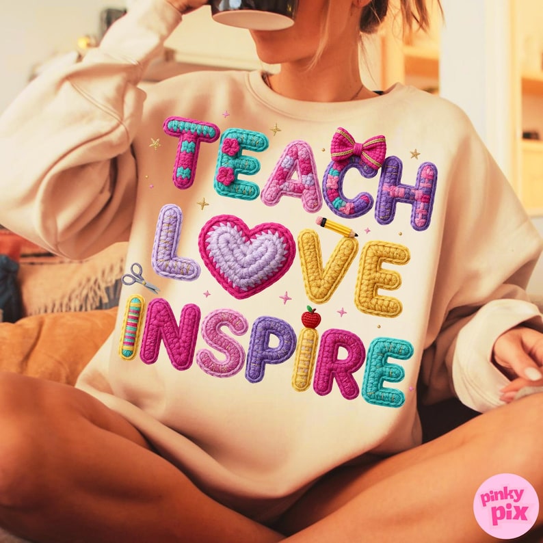 Pu&ograve; includere: Felpa beige con le parole "TEACH LOVE INSPIRE" in lettere colorate e strutturate. Il design include un cuore all'uncinetto, una matita, una mela e un fiocco, con un'estetica giocosa e fatta a mano. La felpa &egrave; uno stile casual e confortevole.