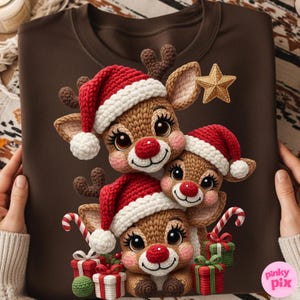 May include: Brown sweatshirt featuring a festive design of three reindeer wearing red and white Santa hats. The reindeer have red noses and are surrounded by gifts and candy canes. A gold star is also present.