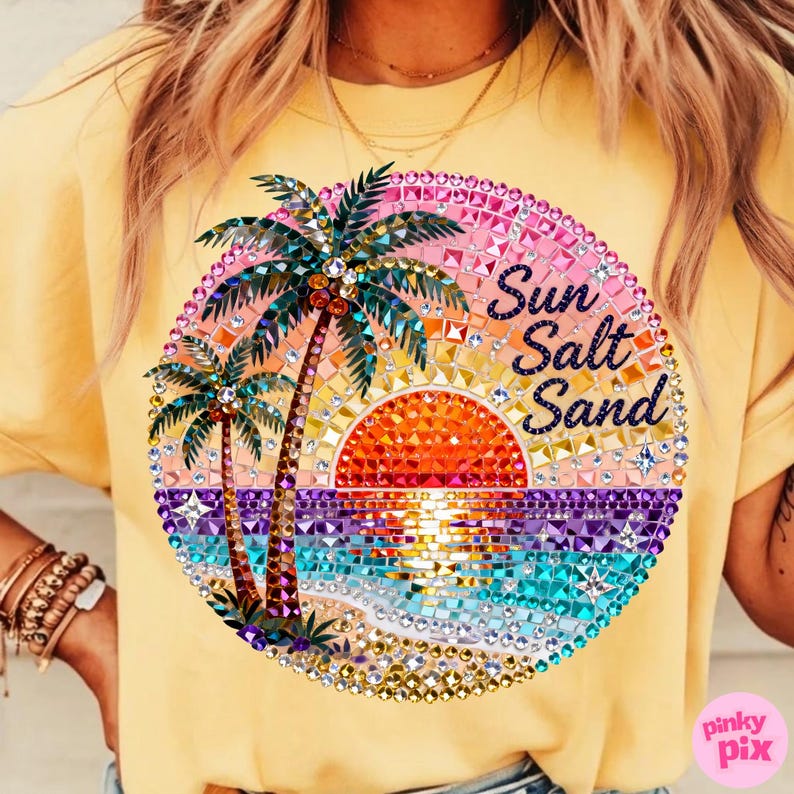 May include: Yellow t-shirt with a vibrant, circular graphic. The graphic features a sunset scene with palm trees, ocean waves, and the words "Sun Salt Sand" in a decorative font. The design is embellished with sparkling rhinestones.