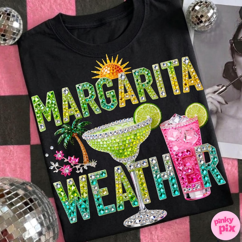 Peut inclure: T-shirt noir avec l'inscription "Margarita Weather" en strass verts, jaunes et bleus. Le motif comprend un verre &agrave; margarita, un cocktail rose, un palmier et un soleil.