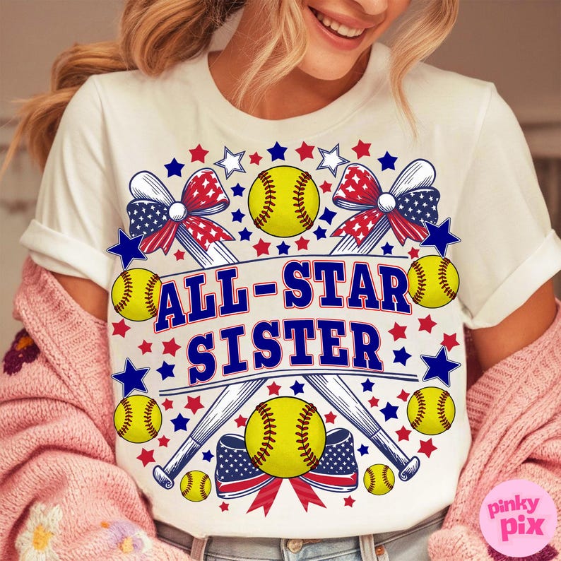 May include: White t-shirt with a softball-themed design. The design includes yellow softballs, baseball bats, and the text "ALL-STAR SISTER" in blue. Red, white, and blue stars and bows complete the patriotic theme.