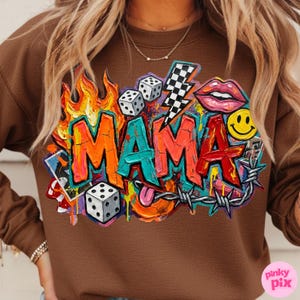 May include: Brown sweatshirt with a colorful graphic that says "MAMA". The design includes flames, dice, a lightning bolt, lips, a smiley face, and barbed wire. The sweatshirt is a solid brown color.
