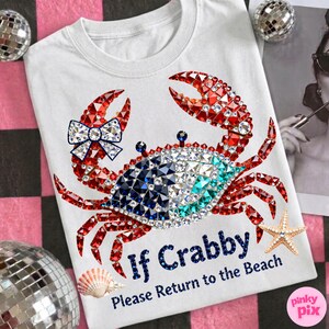 May include: White t-shirt featuring a crab design made of red, blue, and clear rhinestones. The crab has a blue and white bow. Text on the shirt reads "If Crabby Please Return to the Beach."
