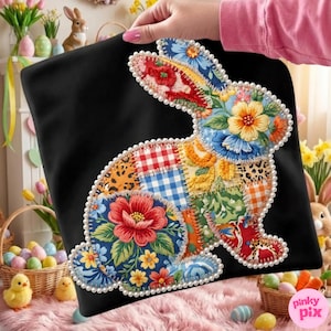 Puede incluir: Cojín negro con un diseño de conejo patchwork colorido. El conejo está adornado con estampados florales, cuadros vichy y estampado de leopardo, delineado con un ribete de perlas. Un artículo decorativo con temática de Pascua.