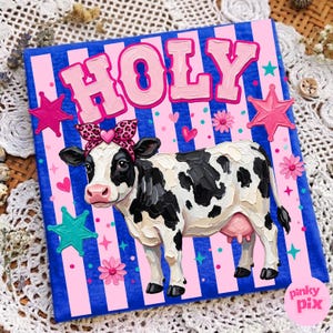 May include: A square canvas with a Holstein cow wearing a leopard print bow, the word "HOLY" in pink letters, and pink and blue accents. The background has pink stripes on a blue background, with pink stars and flowers.
