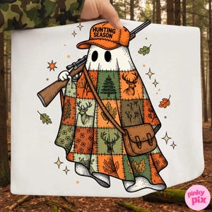 May include: A white ghost illustration wearing an orange cap with the text HUNTING SEASON. The ghost is draped in a patchwork quilt featuring deer, pine trees, and autumn leaves. It carries a rifle over its shoulder and a brown satchel bag.