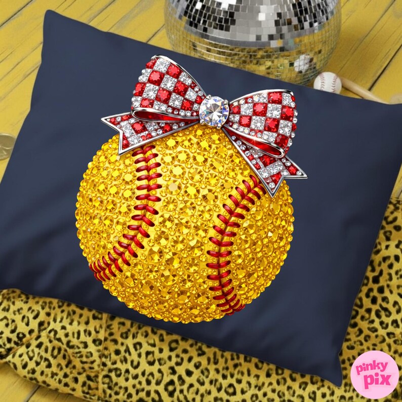 May include: A navy blue cushion featuring a rhinestone-covered baseball with red stitching. A red and white checkered bow with a central diamond sits on top. The baseball is covered in yellow rhinestones.
